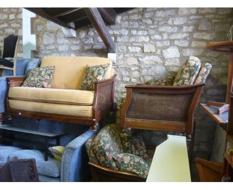 A contemporary Ercol medium elm bergere three piece suite comprising two seat sofa and a pair of matching armchairs with shap