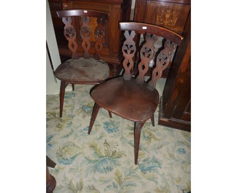 A set of four Ercol dark stained elm and beechwood dining chairs with triple pierced slatted back raised on splayed turned ta