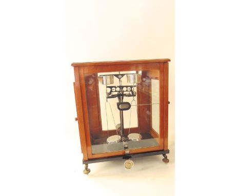 A vintage oak cased assembly of laboratory scales, the case with glazed panels and sliding frontal door, 15 cm tall x 40 cm w