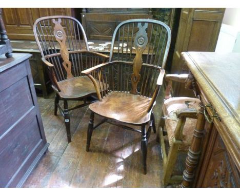 A pair of Georgian Windsor comb back elbow chairs with shaped and pierced splats with bulls eye turning, principally in elm a