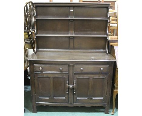 Ercol dark oak dresser, the plate rack top with two shelves, the base with two frieze drawers above two panelled cupboard doo