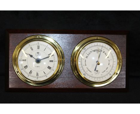 Ships style clock/barometer, with brass surrounds, mounted on a dark stained wall mount, 29.5cm wide