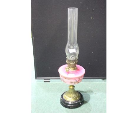 Oil lamp, with foliate decorated puce glass shade, raised on a flared brass stem and ebonised base, 63.5cm high