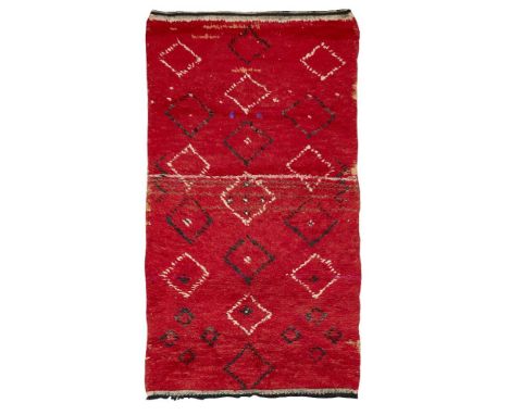 Moroccan, a handwoven long pile wool rugSecond quarter 20th centuryWoven with irregular stylised motifs and lozenge motifs in
