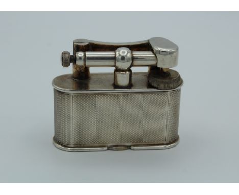 A silver plated Dunhill table lighter of large size, with engine turned decoration. Numbered 737418, 8.5cm wide