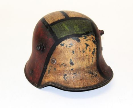 A First War German helmet painted with tri-colour camouflage, leather lining&nbsp;