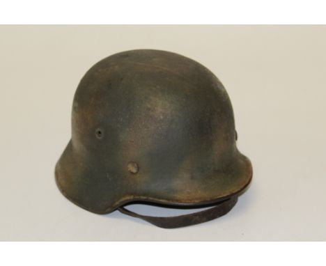 A WWII German helmet with chin strap and leather lining