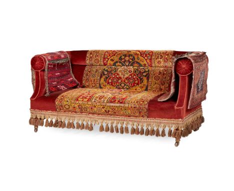  19TH CENTURY with high arms and back, upholstered in claret velvet with a Turkish carpet over-stitched to the central and lo