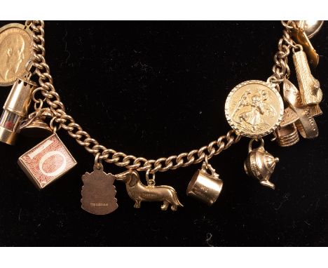A 9ct yellow gold charm bracelet hung with a variety of 9ct gold charms, to include a rugby ball, a dachshund, a St Christoph