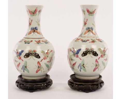 A pair of late 19th Century Chinese pear-shaped vases painted butterflies, 22cm high and the hardwood stands for the same CON