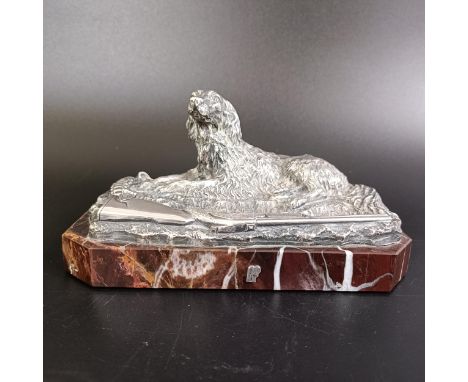 A Russian silver coloured metal gun dog, with shotgun and ammunition belt, on a marble base, 16 cm wide