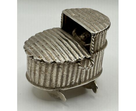 A Dutch silver coloured metal novelty wicker crib with baby, 35.8 g, 3.5 cm high