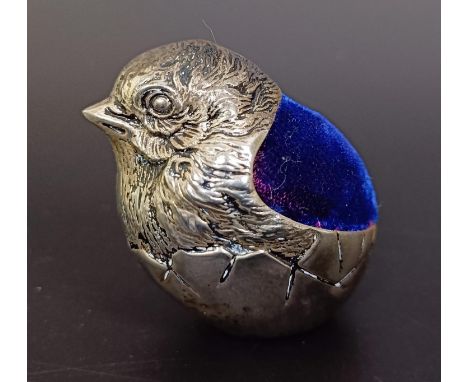 A late 19th/early 20th century novelty silver coloured metal pincushion, in the form of a chick, 4 cm high