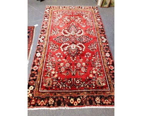 A Lilihan carpet, crimson field with floral motifs, floral vase border, 228 x 140cm.