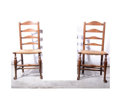 Pair of North Country fruitwood ladder-back dining chairs, with rush seats.