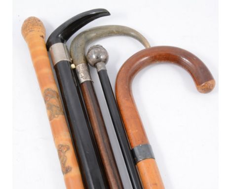 A brass shell case stick-stand, with collection of sticks and a shooting stick.