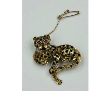 A 9ct gold leopard brooch with ruby eyes and diamond style collar, approximate weight 10.8g and safety chain