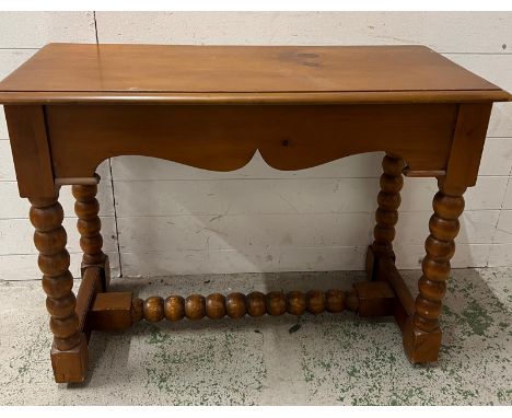 A side table on bobbin style legs (H76cm W100cm D44cm)