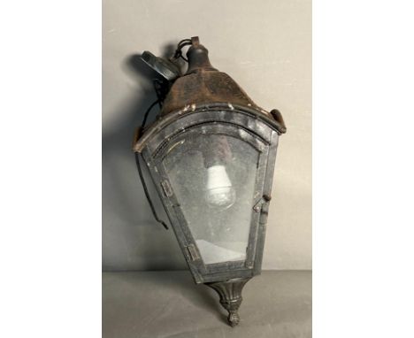 A wall lantern with metal frame and glass panels 