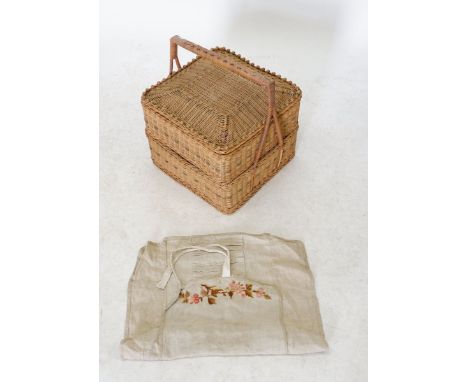 A vintage wicker sewing basket and contents including knitting needle and needle case 