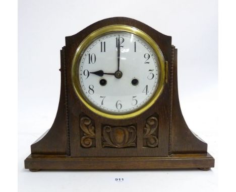 An oak cased mantel clock with carved decoration 