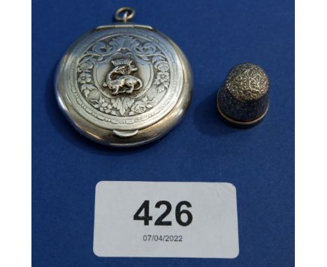 A silver pendant compact with dragon crest, 4cm diameter - unmarked 13.5g and a child's silver thimble 