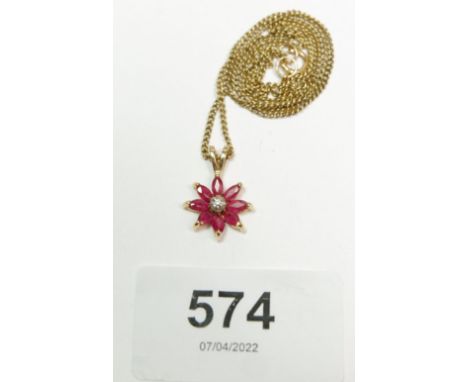 A vintage 9 carat gold ruby and diamond flower form necklace set with a small single cut diamond in a surround of marquise cu