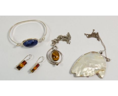 A silver tigers eye and serpent pendant marked E B, a lapis lazuli and silver plated bangle, shell pendant and pair of white 