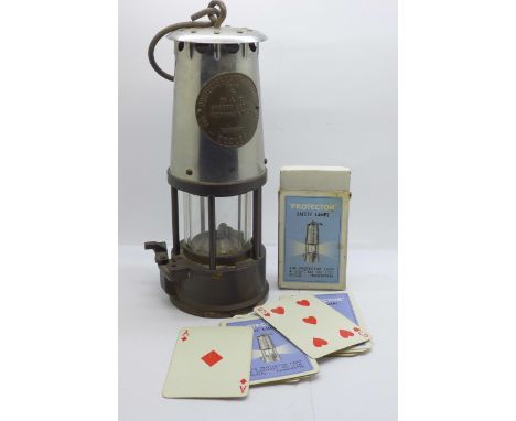 The Protector Lamp & Lighting Co. miner's safety lamp and a pack of aplaying cards by the same company 