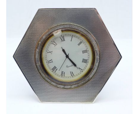 A hexagonal silver mounted quartz clock with backstand 