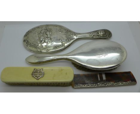 A silver backed mirror with Reynolds angels, two brushes and a comb, a/f 