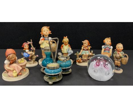 A Linthorpe pottery three piece condiment set on epns stand, Goebel Hummell pottery figures, Caithness glass paperweight.