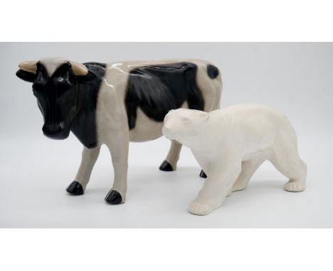 A glazed ceramic cow along with a resin sculpture of a polar bear. H.23cm 