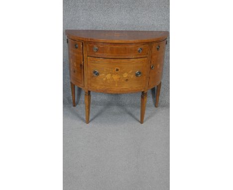 A Continental style demi lune commode with floral satinwood inlay with crossbanding and stringing to the top raised on square