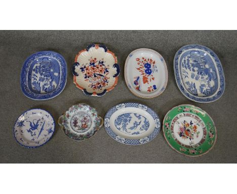 A collection of eight hand painted ceramic platters and plates. Including a Spode blue and white oval platter and a hand pain