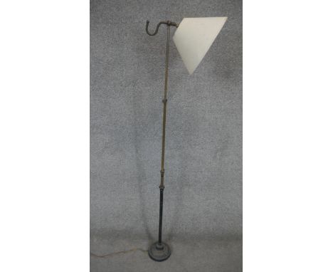 A vintage brass and iron adjustable standard reading lamp with conical glass shade. H.145cm 