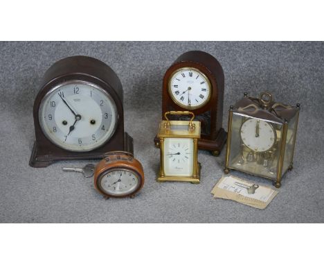 A collection of five vintage clocks. Including a Smith bakelite mantle clock, A mahogany John Elkan mantle clock with carved 