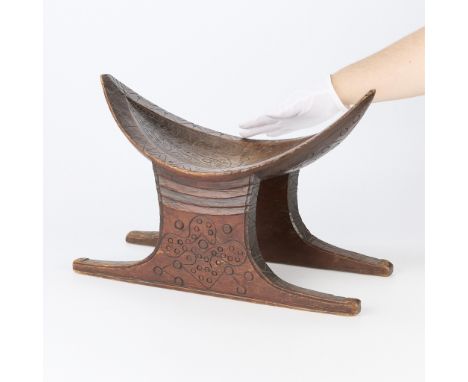 20th century South American Surinamese Djuka carved wooden stool. With a distinctive navette-shaped seat adorned with intrica