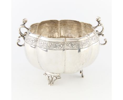 Silver lobed bowl with rose and leaf border details, on three raised feet, with two figural swirl handles. Unmarked. XRF indi