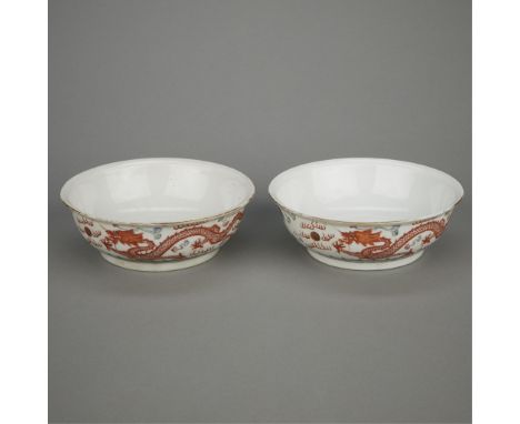 Pair of Chinese Qing porcelain bowls decorated along the sides with a phoenix flying towards a rising sun and a dragon chasin