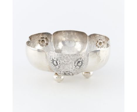 Mexican silver lobed bowl on three raised ball feet. The lobes alternating between textured with repousse flowers and smooth 