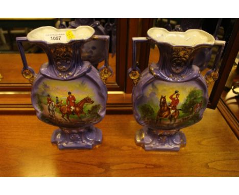 A pair of twin handled vases decorated with hunting scenes 