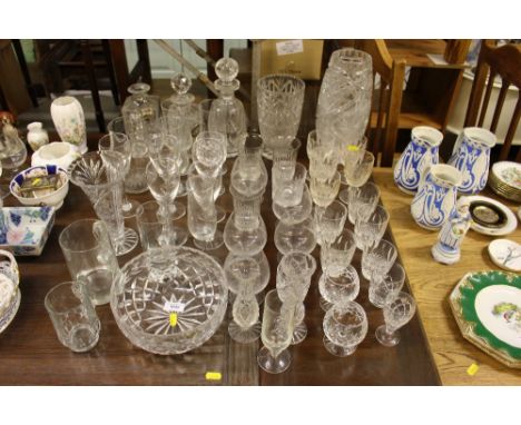 A quantity of various glassware to include decanters and stoppers, one with a silver decanter label, various drinking glasses