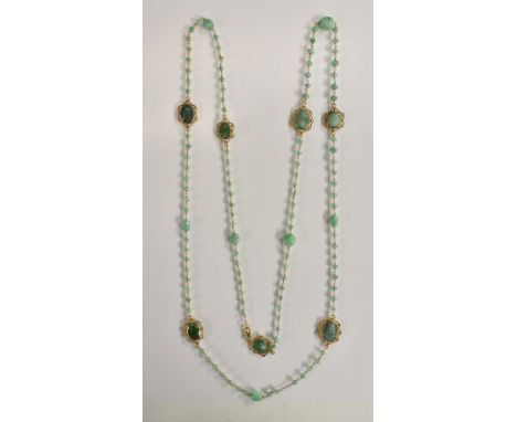 A free form emerald beaded panel necklace, inset with seven oval faceted floral framed emeralds, seven oval larger and emeral