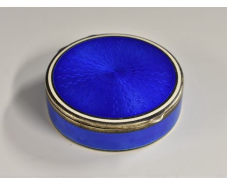 A Continental silver and enamel circular pill box, engine turned and decorated in tones of deep blue, hinged cover with opaqu