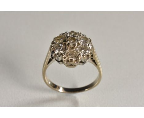 A diamond flower cluster ring, central raised round brilliant cut diamond approx 0.25ct, surrounded by a band of six conformi