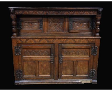 An 18th century oak duodarn, moulded cornice above a central panel flanked by rectangular doors, inlaid with bog oak and holl