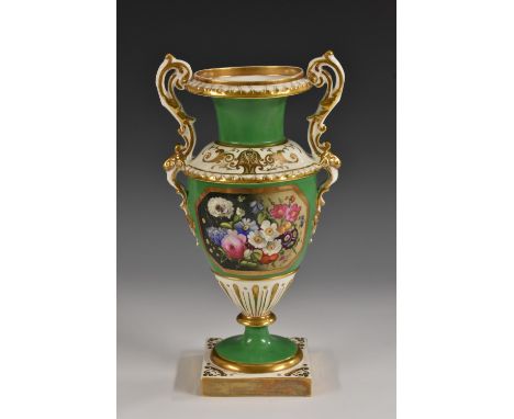 An English porcelain pedestal two handled vase, well painted with flowers in a gilt octagonal panel on an avocado green groun