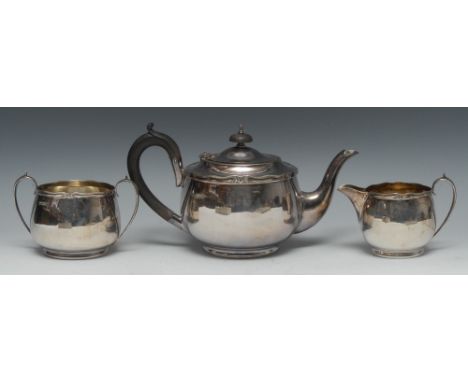 A George VI silver three piece tea service, comprising teapot, milk jug and sugar basin, scroll borders, scroll-capped handle