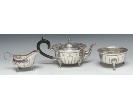 An 18th century Irish style silver three-piece tea service, comprising teapot, milk jug and sugar basin, spirally-fluted and 